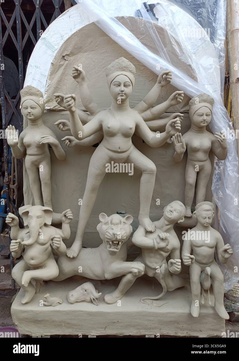 Tonidol der Göttin Durga in der Herstellung mit ihren Kindern, fotografiert in einer traditionellen Handwerkstatt in Kumartuli, Kalkutta, Juli 2025. Stockfoto