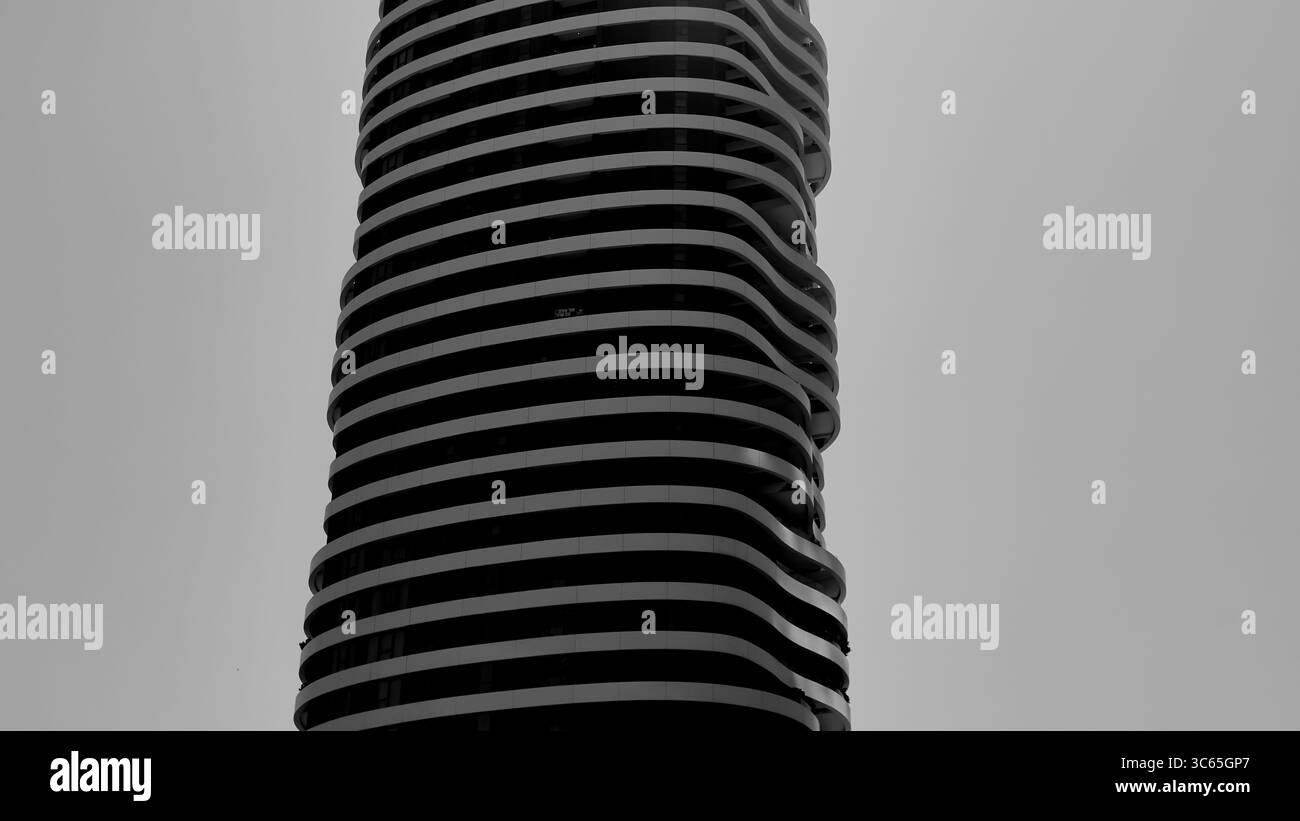 Die monochrome Studie des Alpha Tower in Tel Aviv-Jaffa hebt die hügeligen Balkone und die schlanken Linien vor dem Himmel hervor und zeigt die skulpturale moderne Form. Stockfoto