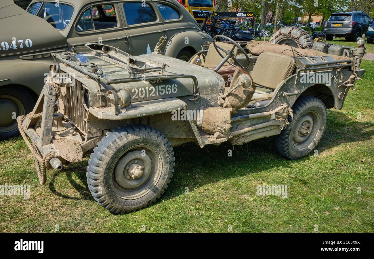 20. April 2025: Limmen-Niederlande: Ein mit Schlamm bedeckter Jeep aus dem Zweiten Weltkrieg wird neben einem Stabwagen der US-Armee geparkt, während ein historisches Militärfahrzeug zusammentritt Stockfoto