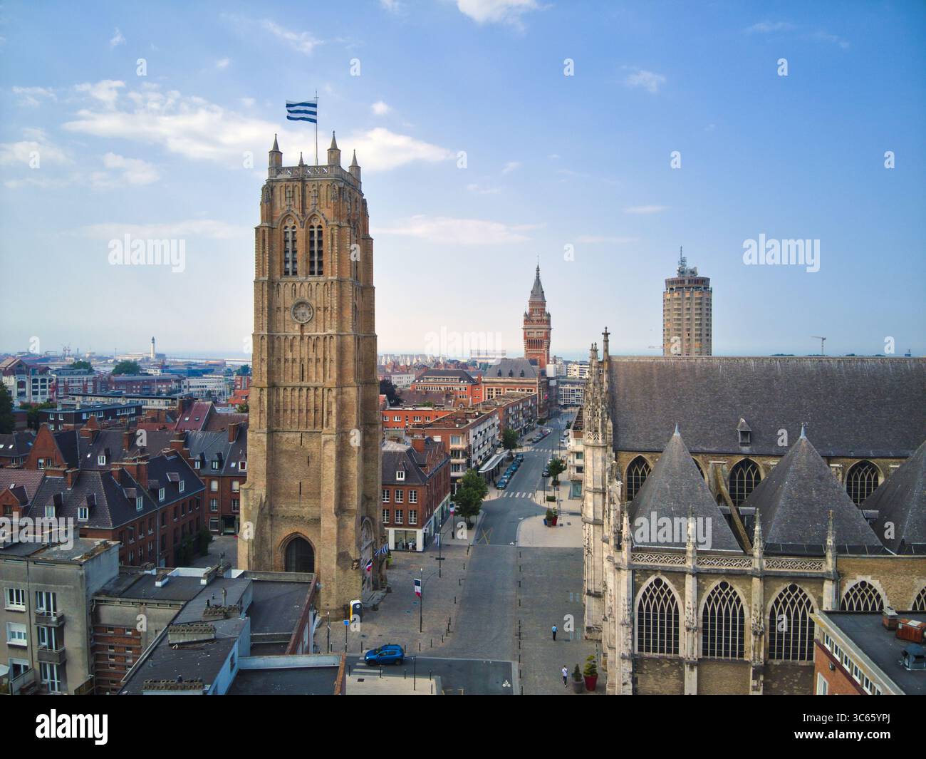 Blick aus der Vogelperspektive auf den Turm der Kirche Saint-Eloi, hoch vor der Skyline, ein Leuchtturm der Geschichte und Schönheit, Dunkirk, Frankreich. Stockfoto