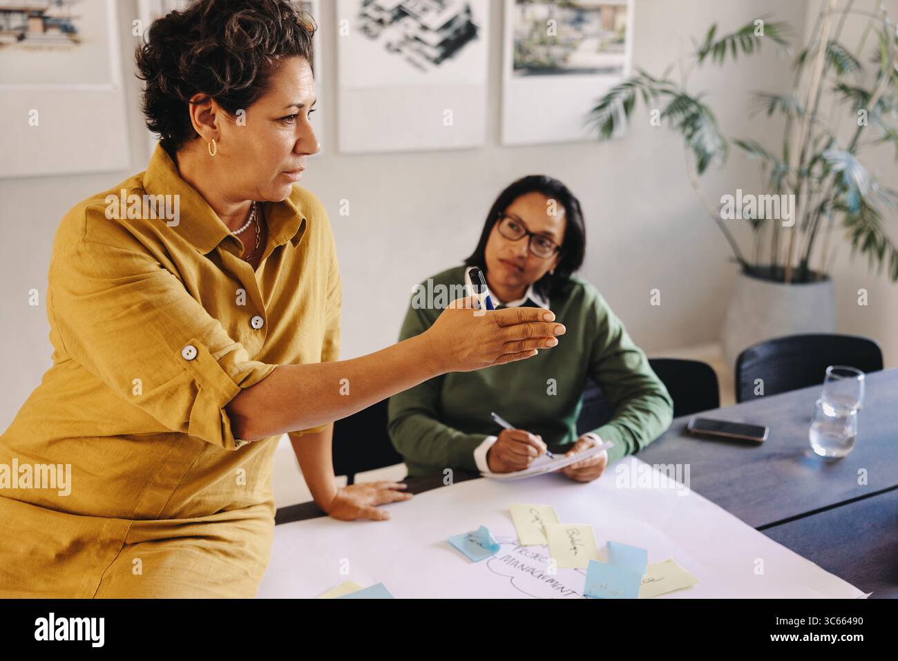 Eine professionelle Führungskraft führt ein Team-Meeting durch und diskutiert Ideen und Strategien. Die Interaktion spiegelt ein produktives berufliches Umfeld wider Stockfoto