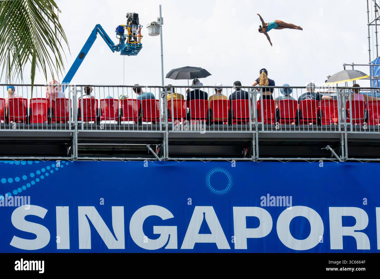 Singapur, Singapur - 25. Juli 2025: Blick auf einen Taucher, der über dem Siloso Beach Walk durch die Luft schwingt, eine lebhafte Darstellung von Athletik vor der Kulisse der Zuschauer und der Eventinfrastruktur. Stockfoto