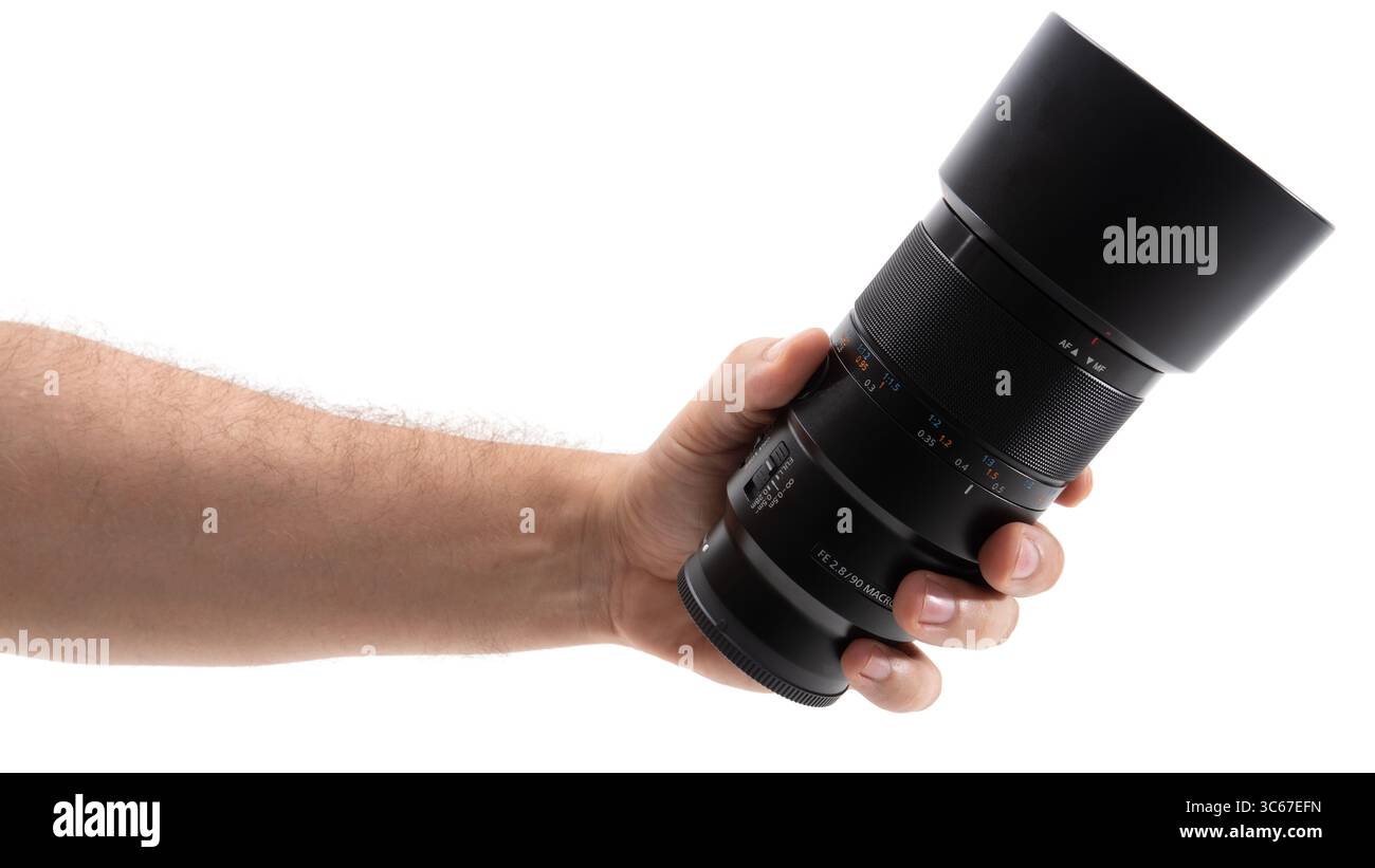 Hand, die ein Kameraobjektiv zum Fotografieren hält Stockfoto