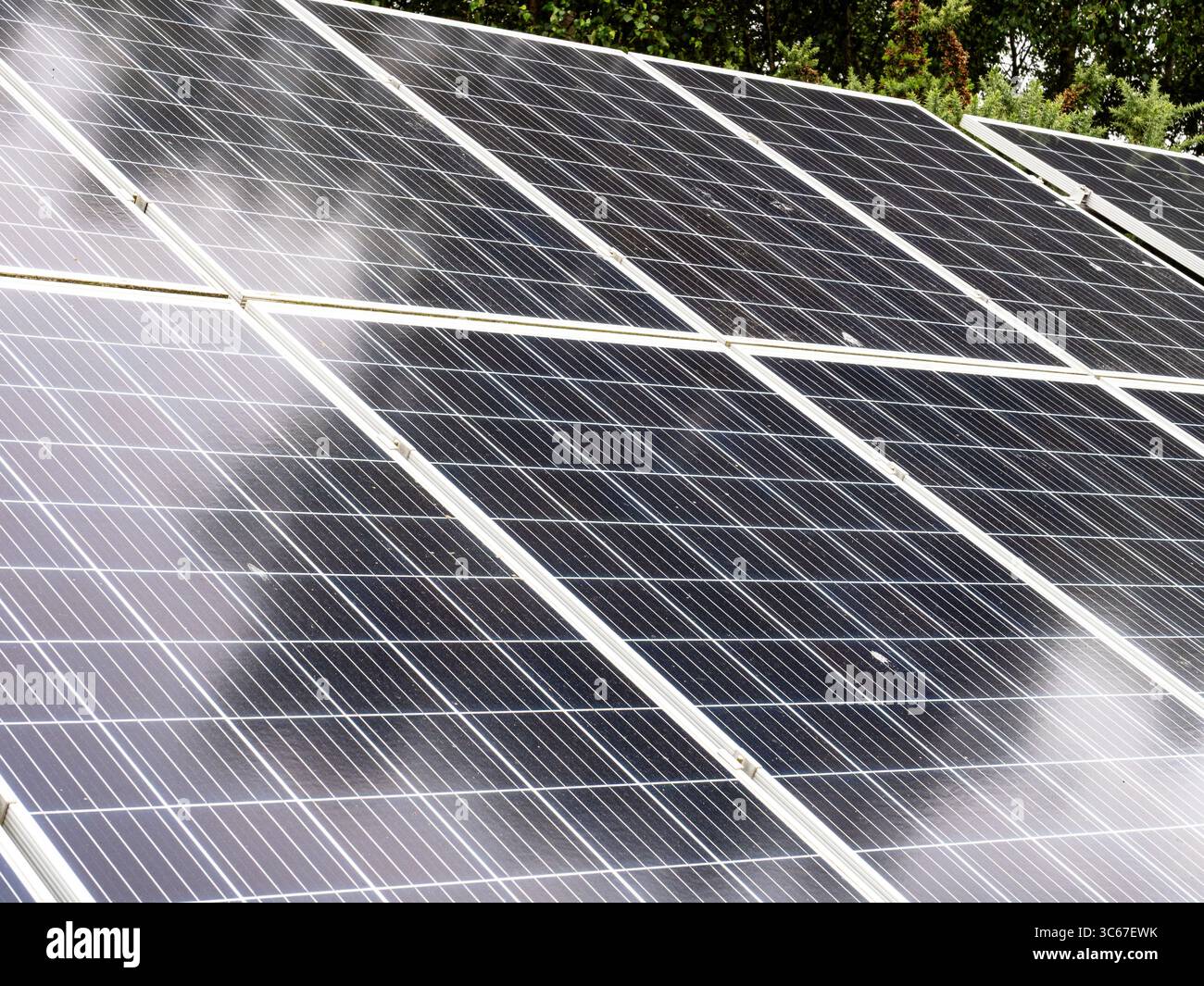 Eine Reihe von bodenmontierten Solarpaneelen, die sich bis in die Ferne erstrecken Stockfoto