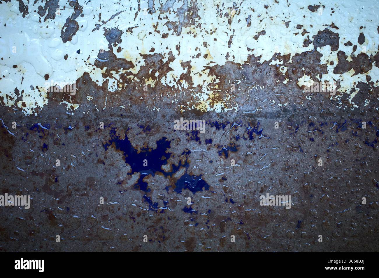 Wassertropfen auf eine rostige Metalloberfläche in flachem Fokus. Stockfoto