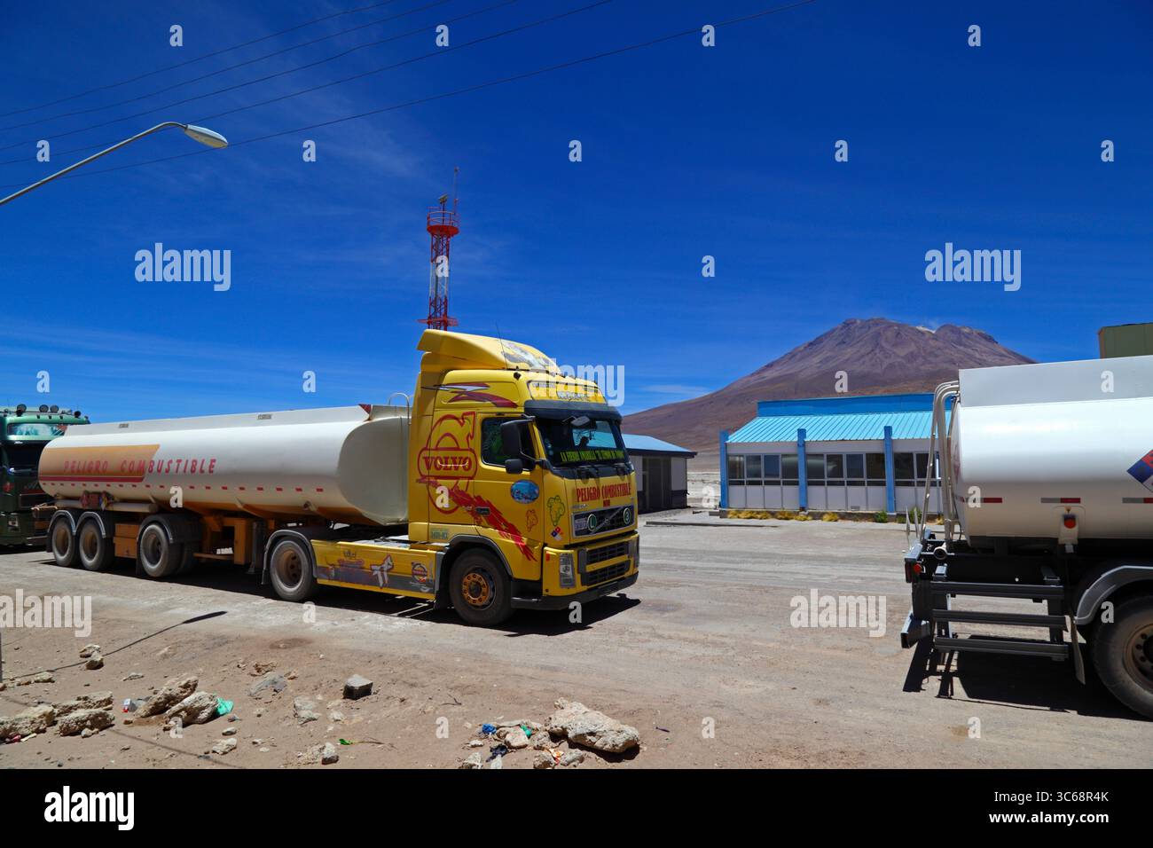 Volvo-Tanker wartet auf die Einreise nach Bolivien an den Grenzkontrollen bei Ollagüe, Vulkan Aucanquilcha im Hintergrund, Chile Stockfoto