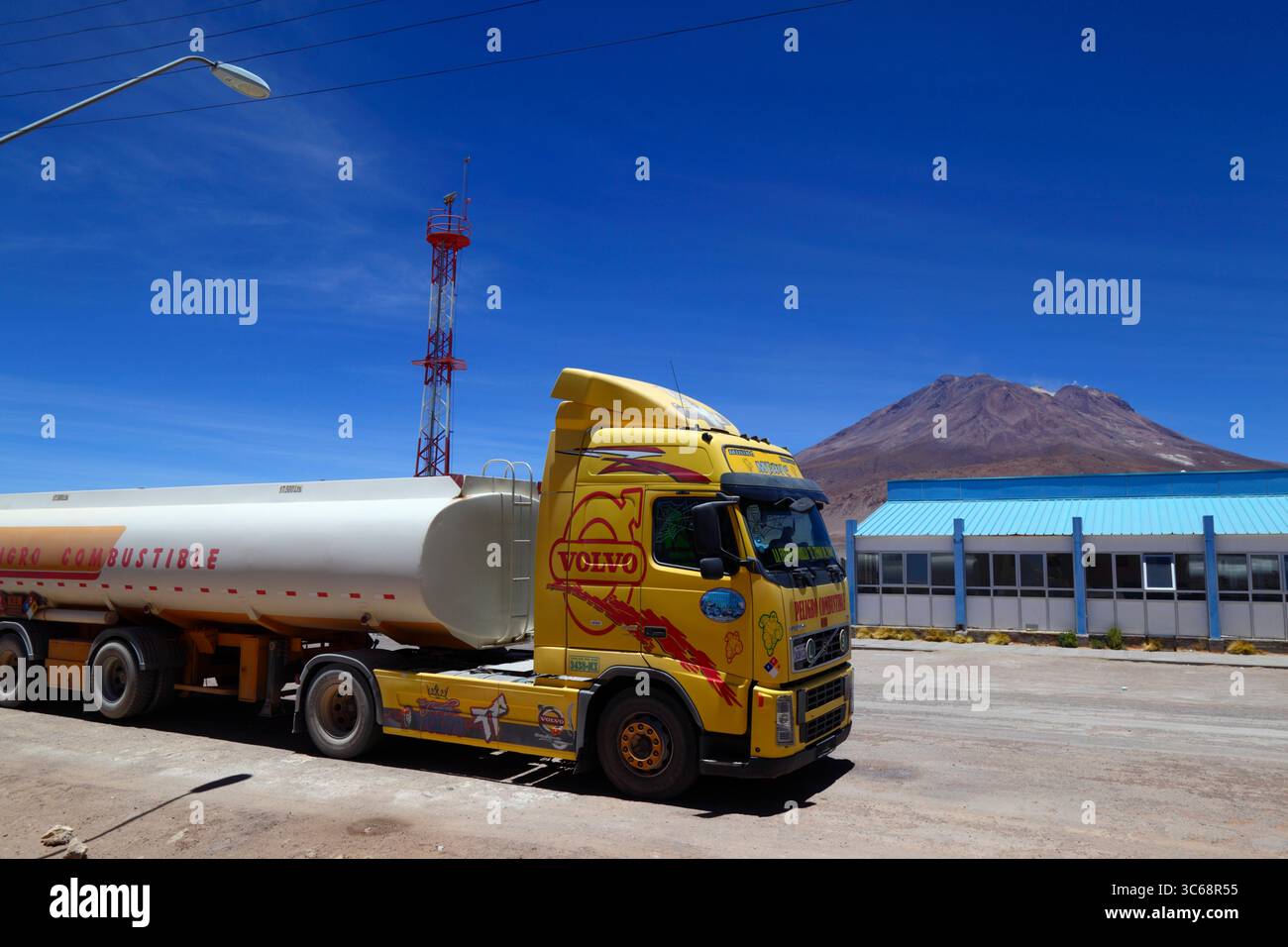 Volvo-Tanker wartet auf die Einreise nach Bolivien an den Grenzkontrollen bei Ollagüe, Vulkan Aucanquilcha im Hintergrund, Chile Stockfoto