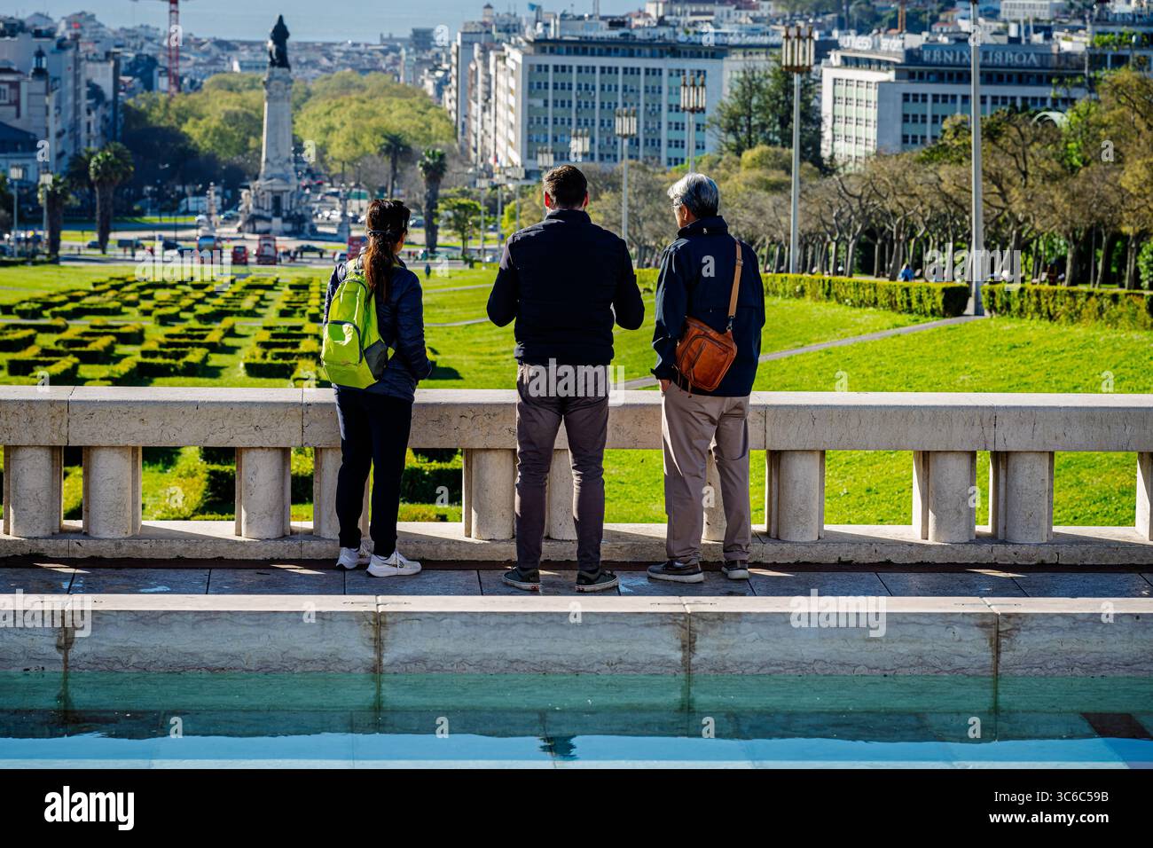 Lissabon, Portugal – 31. März 2025. Eine weibliche und zwei männliche Touristen blicken über den Eduardo VII Park und die Gärten in Richtung Zentrum von Lissabon. Stockfoto