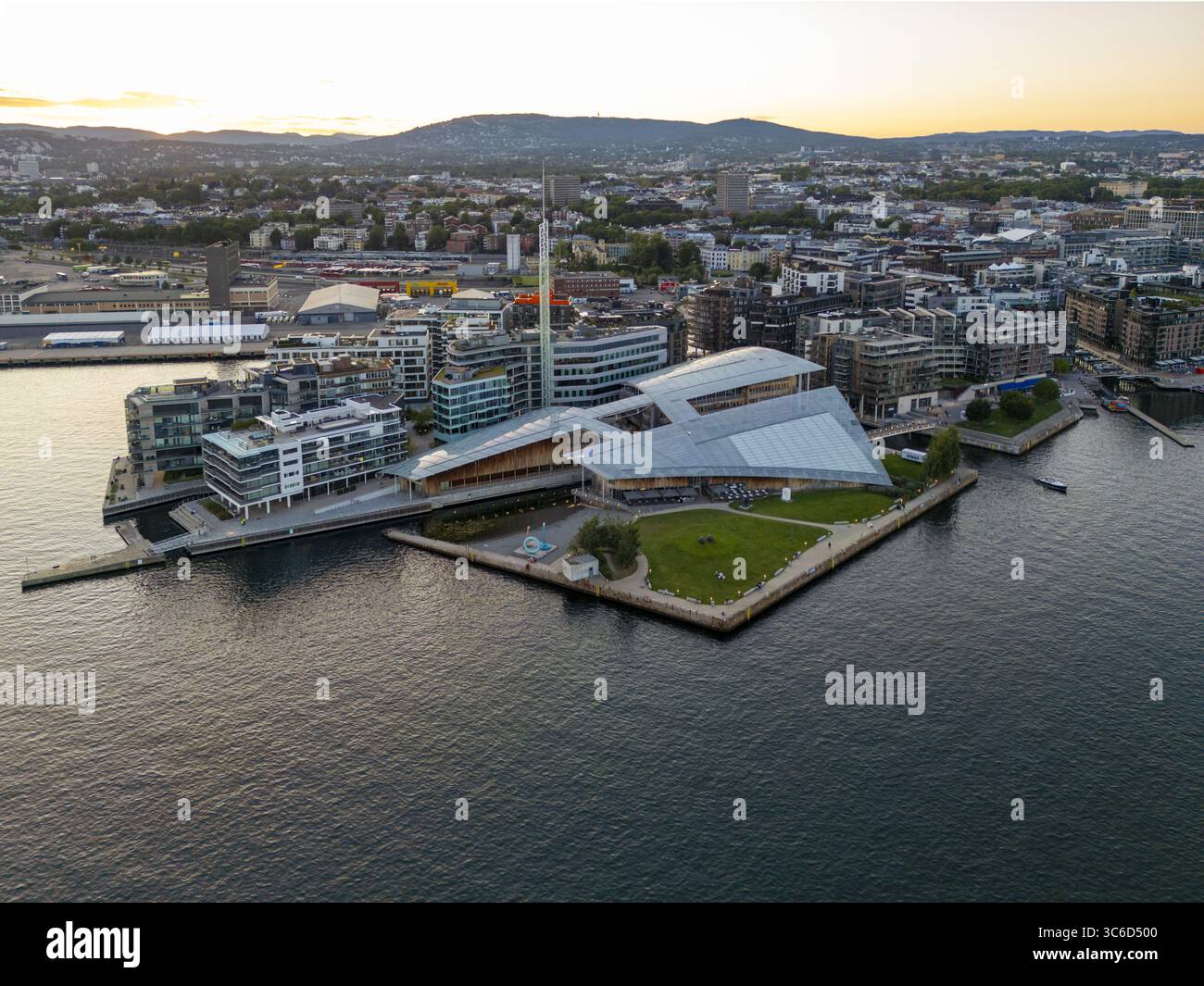 Aus der Vogelperspektive des Astrup Fearnley Museums mit seinen markanten segelartigen Dächern, die im Sonnenlicht vor dem tiefblauen Wasser schimmern, Oslo, Norwegen. Stockfoto