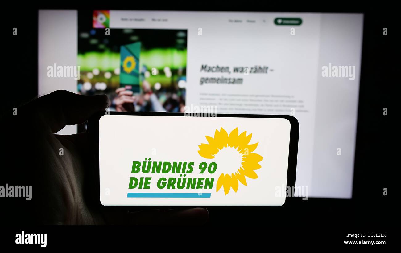Stuttgart, Deutschland - 25.06.2025: Handybesitzer mit Logo der deutschen Partei Buendnis 90 die Grünen auf dem Bildschirm vor der Webseite. Stockfoto