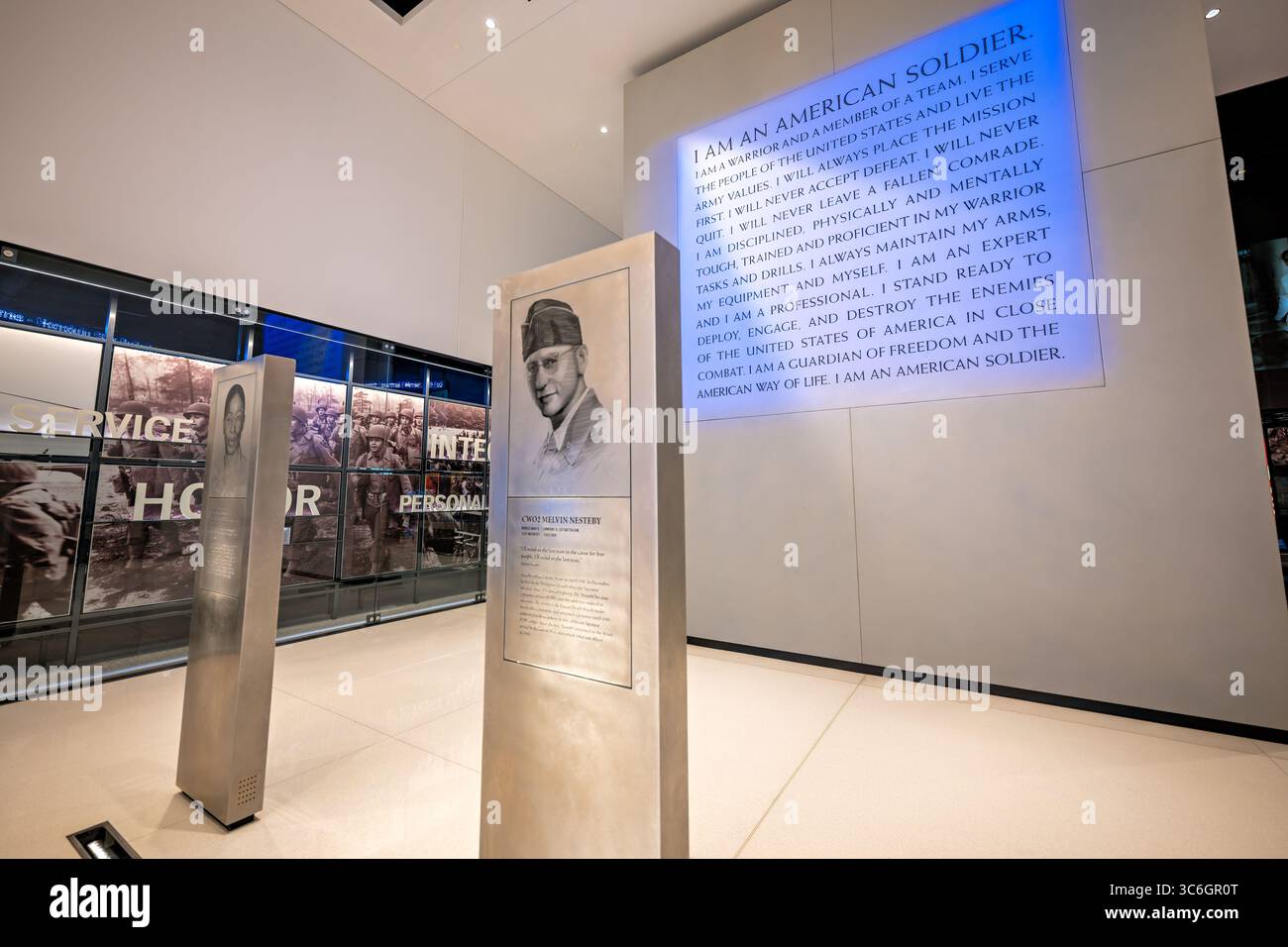 FORT BELVOIR, Virginia – das Soldier's Creed ist an der Rückwand hinter der Soldiers' Stories Gallery im National Museum of the United States Army ausgestellt. Das Glaubensbekenntnis, das „Ich BIN EIN AMERIKANISCHER SOLDAT“ beginnt, beschreibt die grundlegenden Werte und Verpflichtungen des Personals der US-Armee, einschließlich des Engagements für Mission, Team und das amerikanische Volk. Die Galerie zeigt freistehende Pylonen mit geätzten Bildern von Gesichtern der Soldaten sowie biografischen Informationen, wobei jeder Pylon persönliche Berichte von Soldaten aus verschiedenen Konflikten in der amerikanischen Militärgeschichte zeigt. Die Stockfoto
