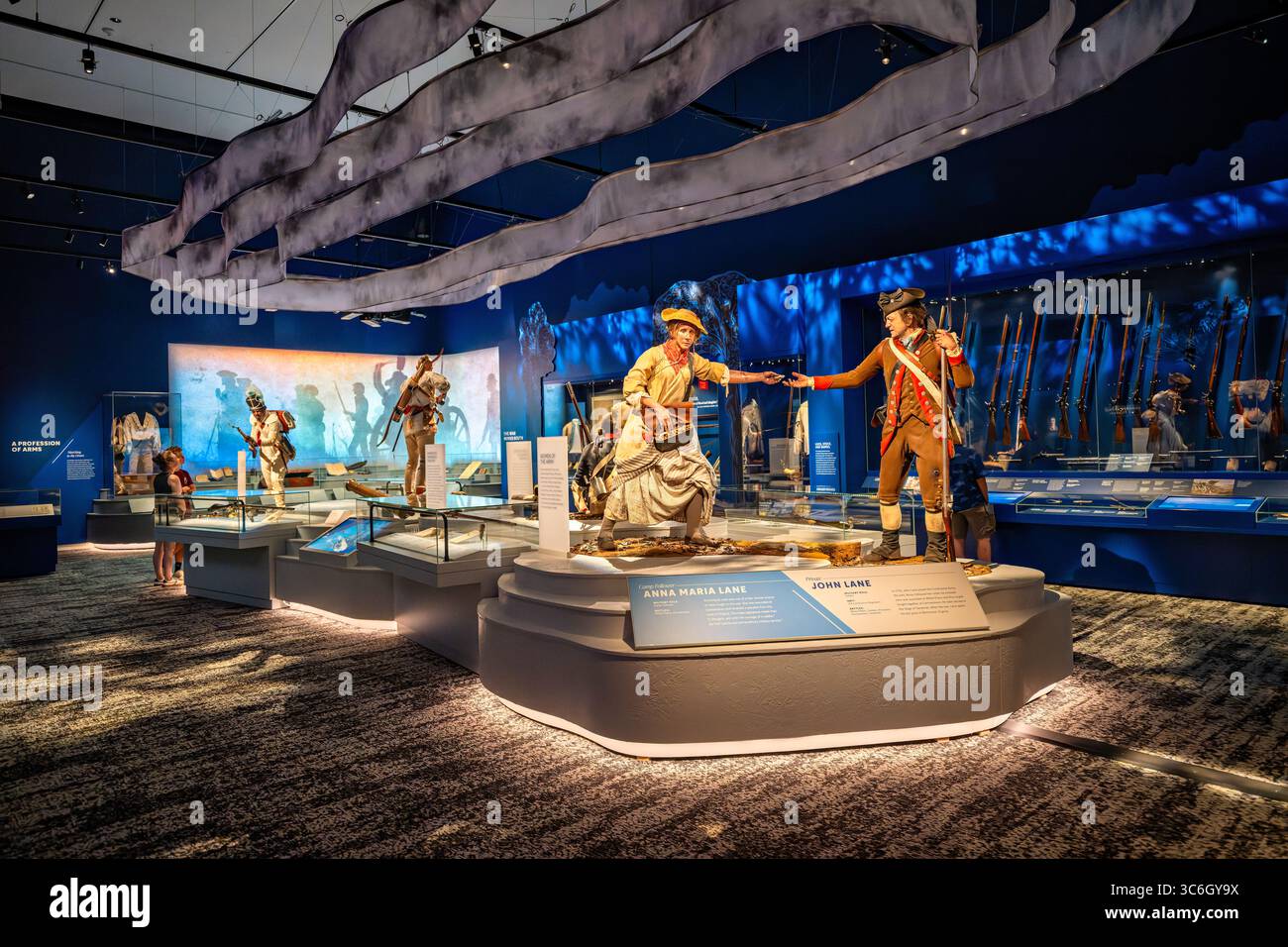 FORT BELVOIR, Virginia – die Ausstellung „Call to Arms: The Soldier and the Revolutionary war“ zeigt Figuren von Anna Maria Lane und ihrem Ehemann John Lane, die beide während der Amerikanischen Revolution dienten. Anna Maria Lane, dargestellt als Lagerankündigung, war eine der wenigen Frauen, die im Krieg gekämpft haben und wurde in der Schlacht von Germantown verwundet und erhielt später eine Rente von Virginia für ihren „außergewöhnlichen Militärdienst“. John Lane diente als Privat im 3. Connecticut Regiment und nahm an Schlachten Teil, darunter White Plains, Trenton, Princeton, Germantown und die Belagerung von Savanna Stockfoto