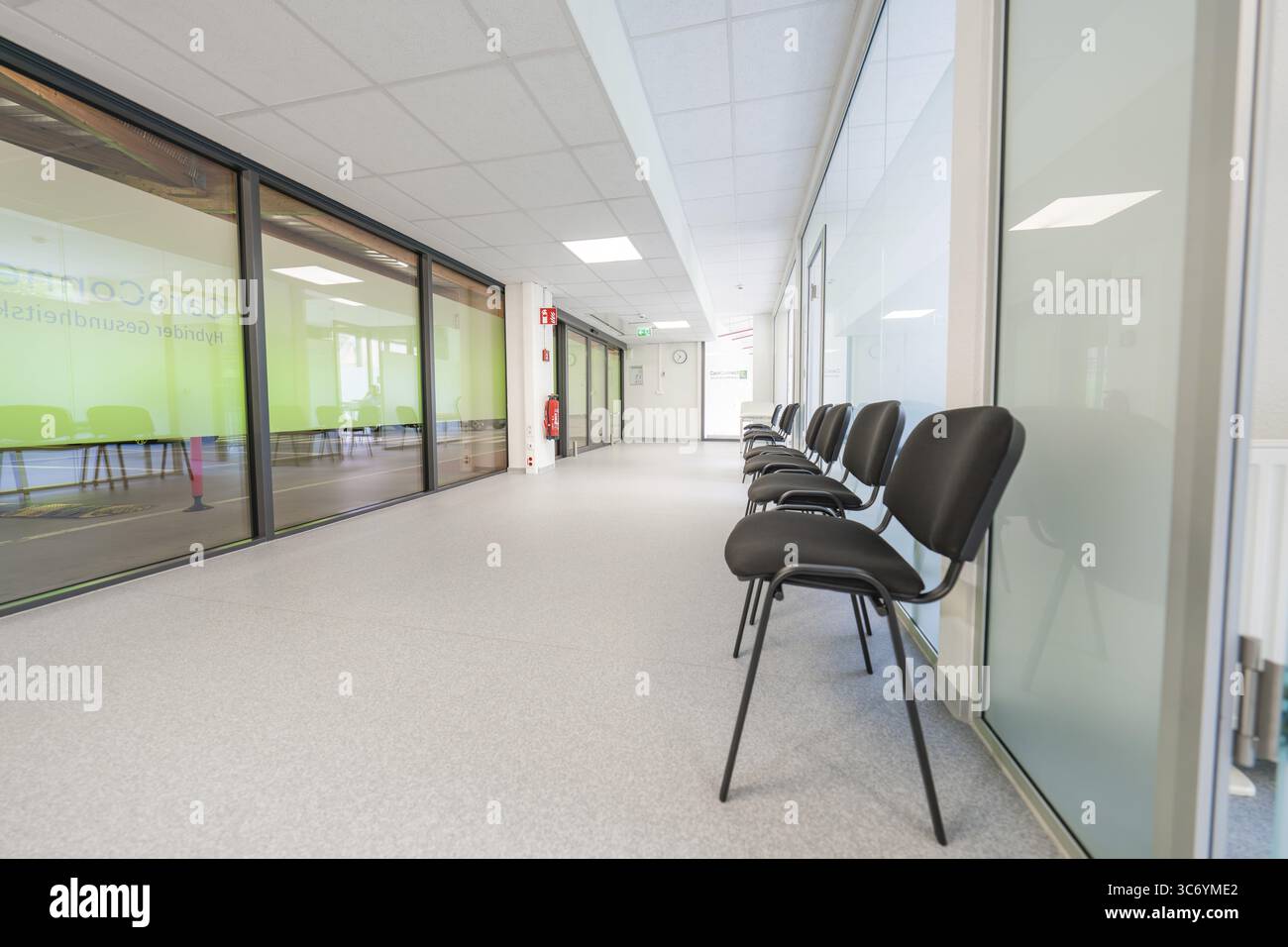 Moderner, heller Flur mit Stühlen und Glastüren im Wartebereich, Care Connect, Impfkiosk für Flüchtlinge, Calw, Deutschland Stockfoto