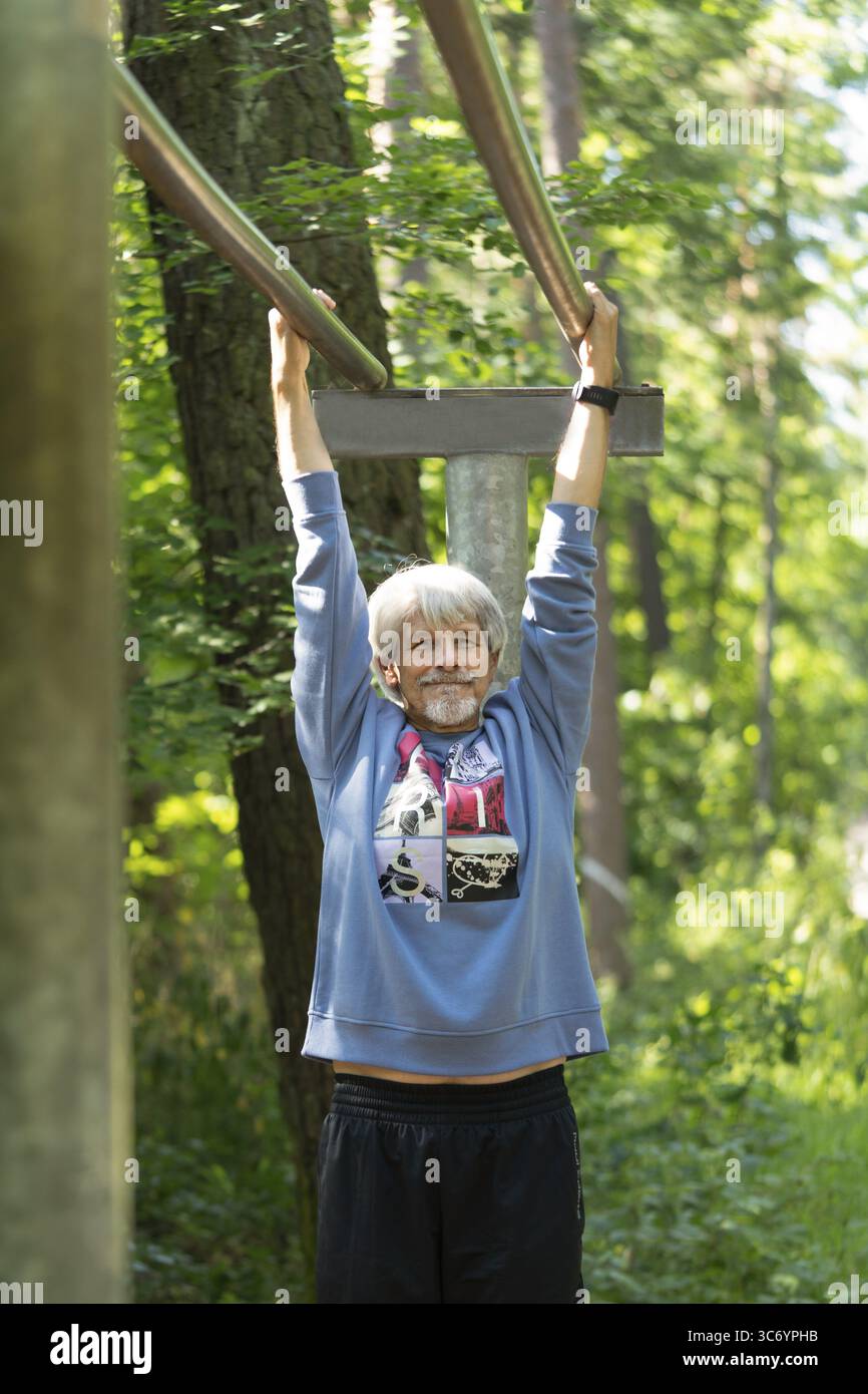 Fitter, älterer Mann übt an einem Gerät, Trimmweg Stockfoto