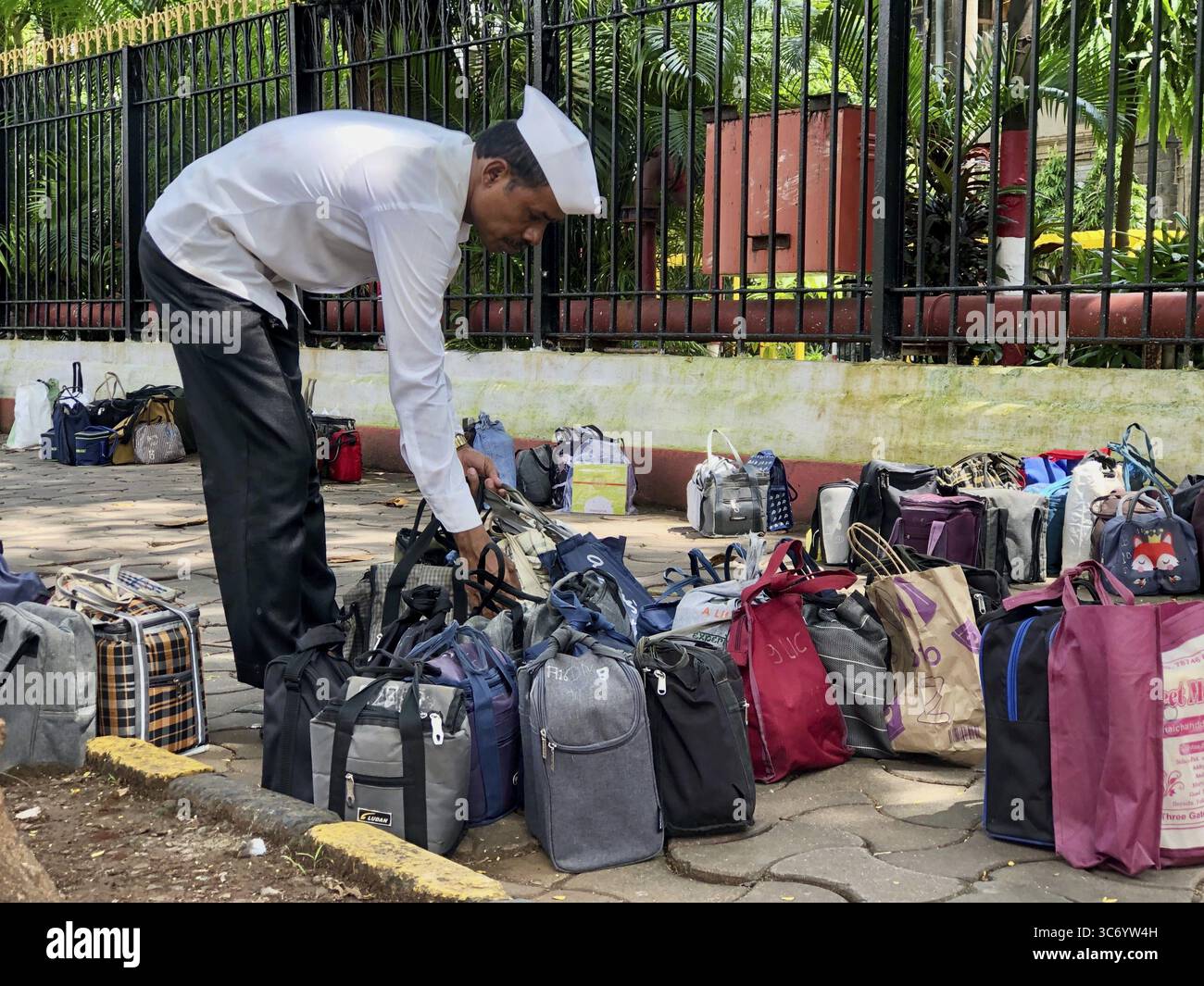 Dabbawala arrangiert Taschen auf der Straße, um sie zu liefern, Churchgate Station, Mumbai, Maharashtra, Indien Stockfoto