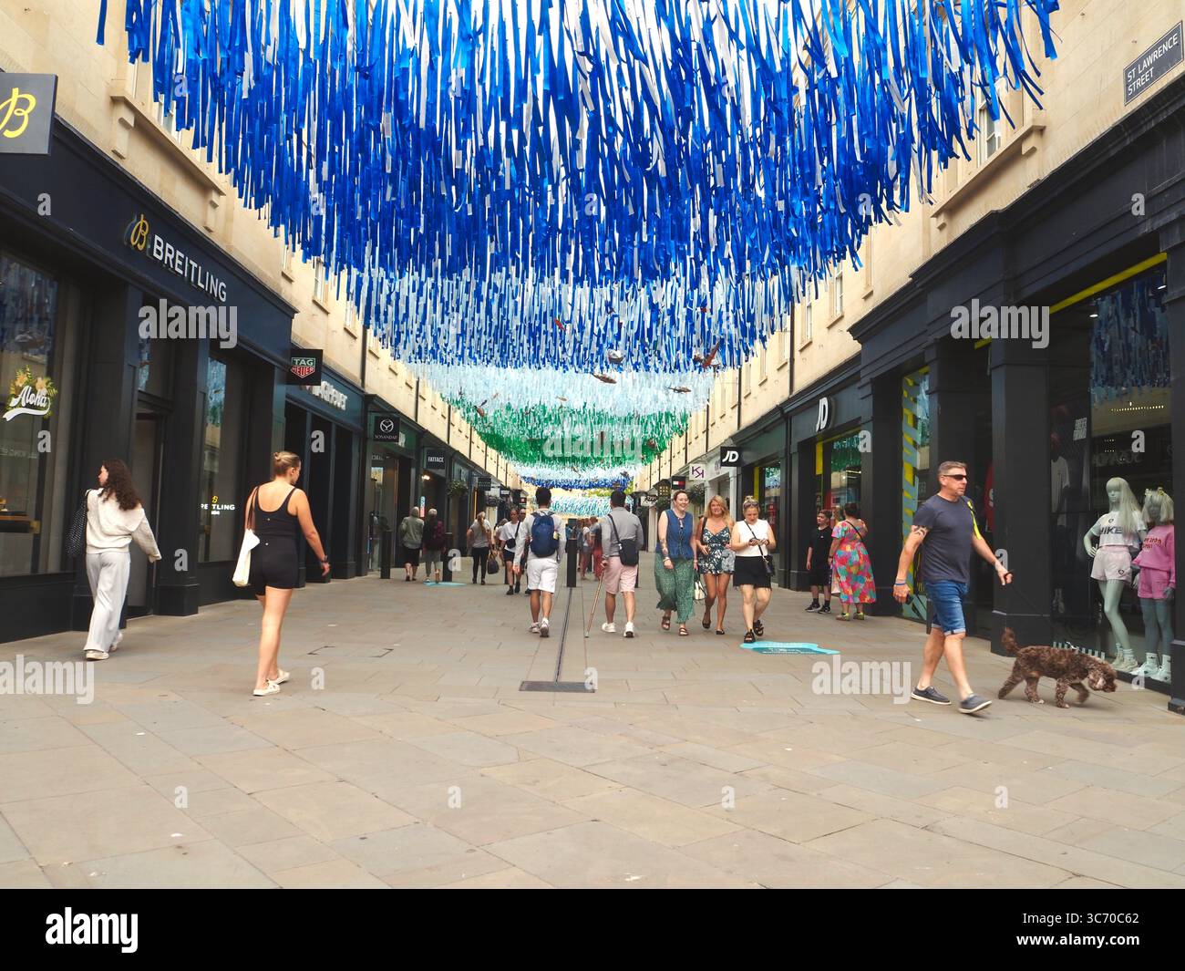 Einkaufsmöglichkeiten im Southgate Shopping Centre, Bath, Somerset, mit Markengeschäften im Blick und blauen und grünen Meeresmotiven über dem Dach. Stockfoto