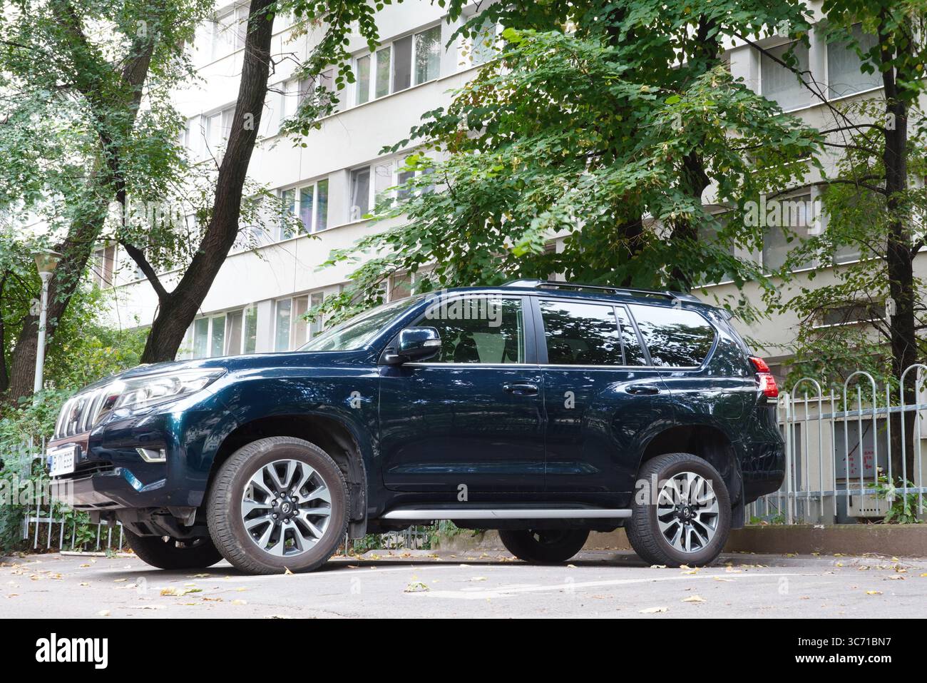 Bukarest, Rumänien – 31. Juli 2025: Nahaufnahme des blauen Autos des Toyota Land Cruiser auf dem Parkplatz in der Nähe eines Wohnblocks Stockfoto