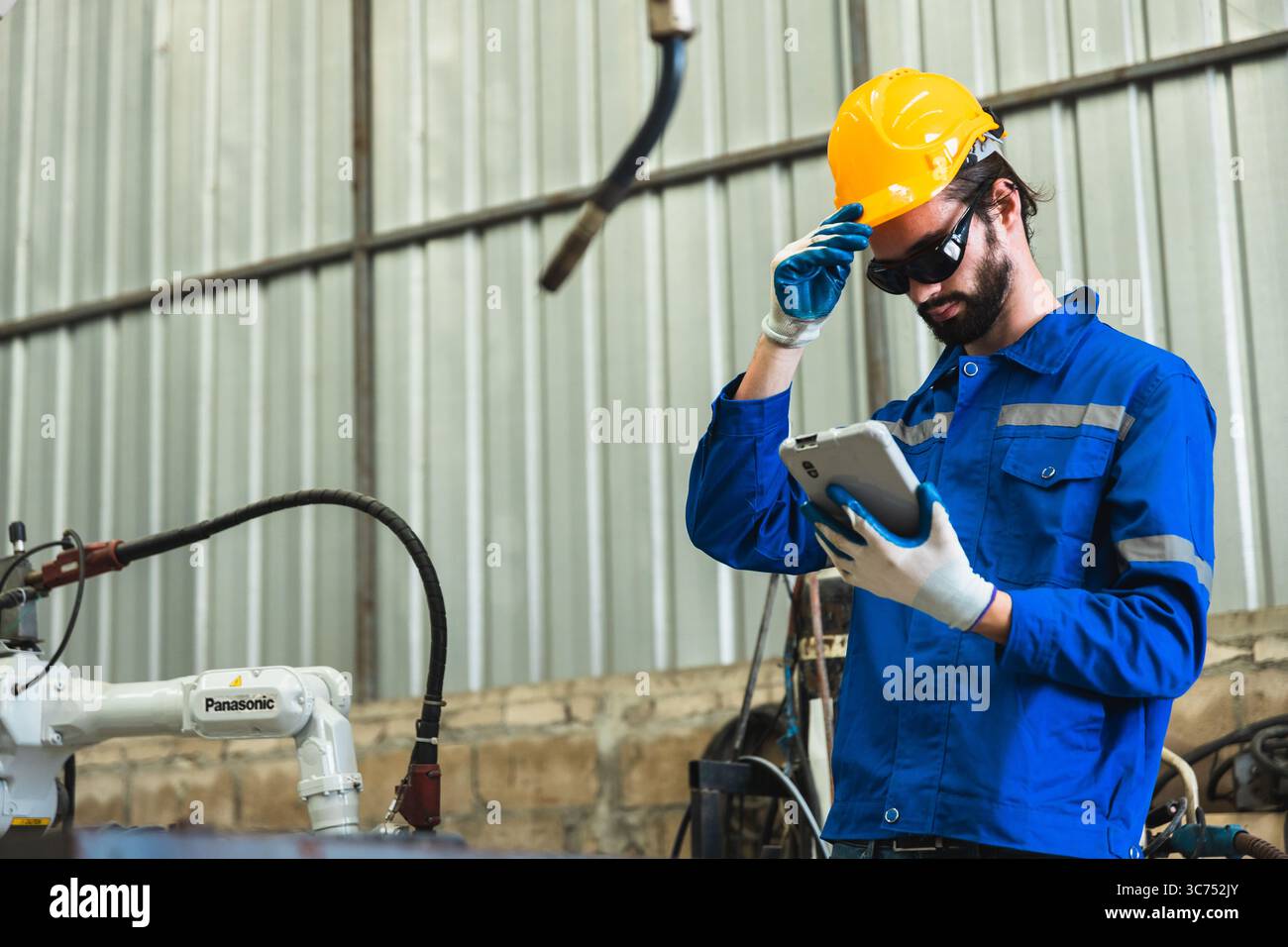 Roboteringenieur überprüft einen Roboterarm in einer Industriefabrik Stockfoto