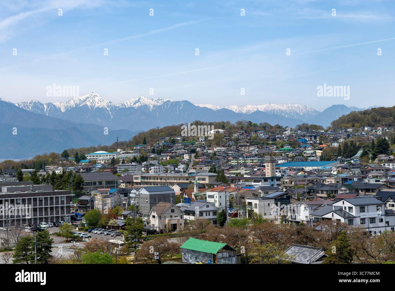 Matsumoto, Japan - 22. April 2025; Stadtlandschaft mit schneebedeckten Bergen im Hintergrund Stockfoto