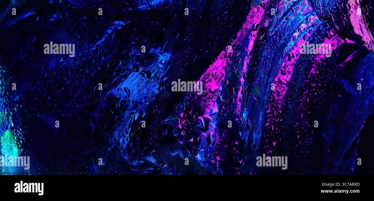 Abstrakte Nahaufnahme der nassen Glasoberfläche mit leuchtenden blauen und rosa Neonreflektionen, Wassertropfen und flüssigen Pinselstrichtexturen. Stockfoto