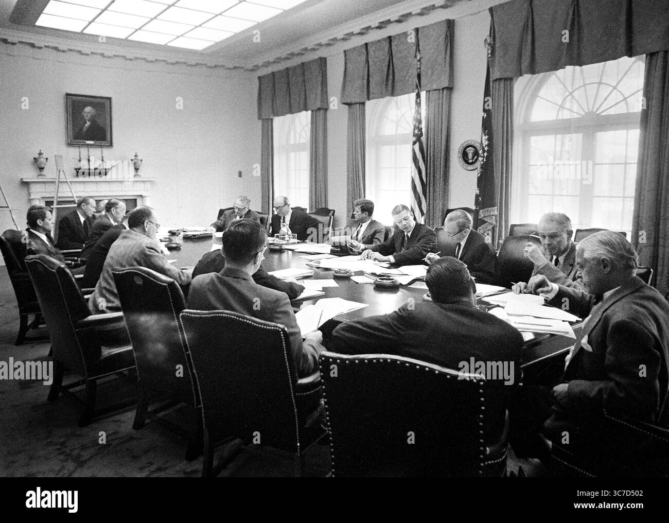 Exekutivausschuss des Nationalen Sicherheitsrats (im Uhrzeigersinn von der oberen rechten Seite des Tisches: unter Außenminister George Ball, Außenminister Dean Rusk, US-Präsident John F. Kennedy, Verteidigungsminister Robert S. McNamara, stellvertretender Verteidigungsminister Roswell Gilpatric, Vorsitzender der Joint Chiefs of Staff General Maxwell D. Taylor, stellvertretender Verteidigungsminister für internationale Sicherheitsangelegenheiten Paul Nitze, stellvertretender Direktor der United States Information Agency Donald Wilson, Sonderberater des Präsidenten Theodore C. Sorensen, Sonderassistent des Präsidenten für National S Stockfoto