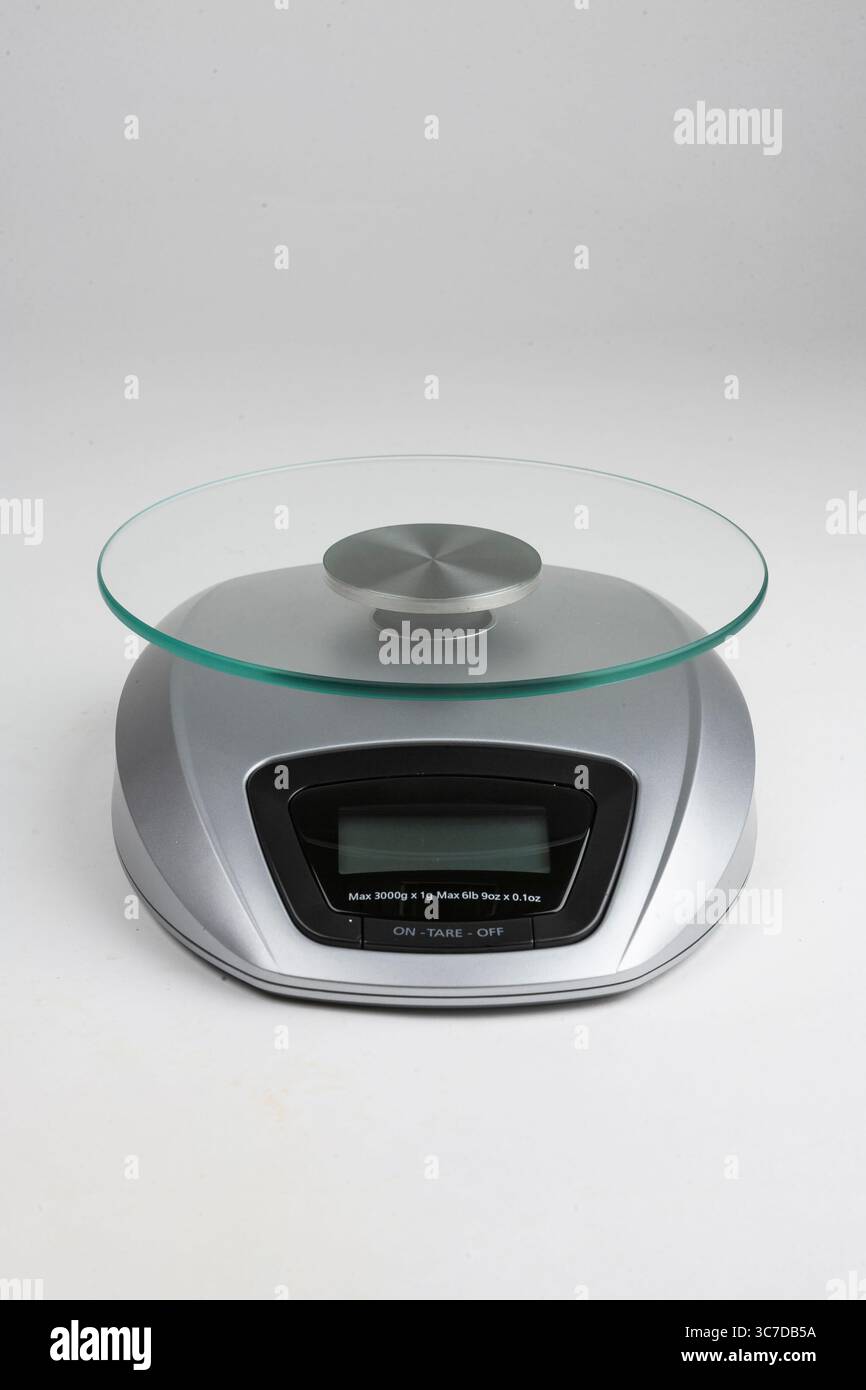 Eine moderne digitale Küchenwaage mit Glasplattform, ideal für präzise Messungen beim Kochen und Backen. Stockfoto
