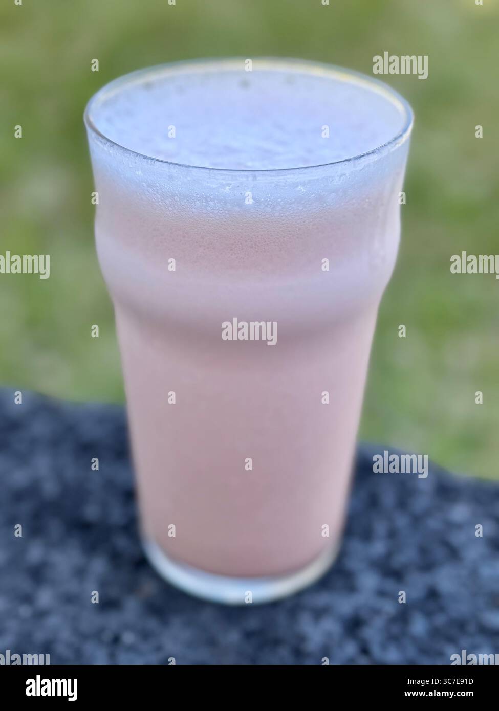 Erfrischendes Wassermelonengetränk mit Eis und Tonic Water, serviert in einem Glas auf einem Basalttisch im Freien. Stockfoto