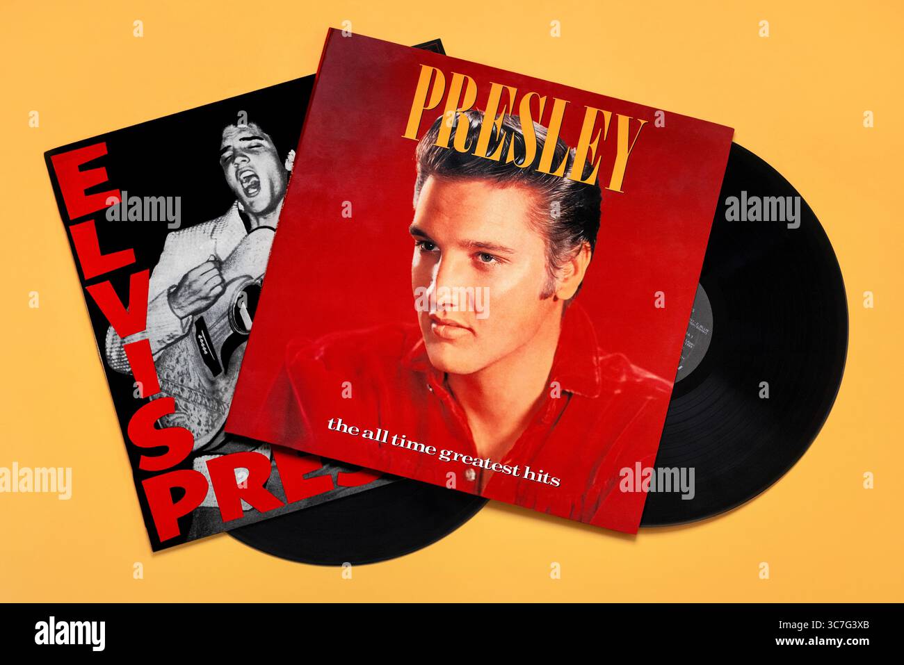 Blick von oben auf die klassischen Schallplatten von Elvis Presley auf gelbem Hintergrund. Illustrativer Leitartikel Stockfoto