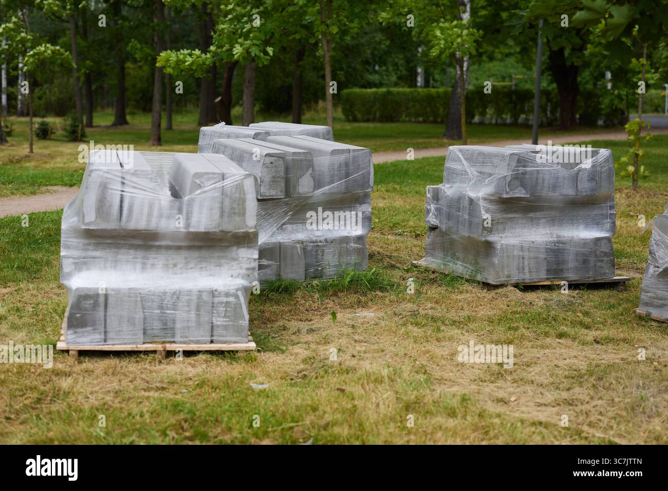 Paletten mit Baumaterialien sind zum Schutz sicher in Kunststofffolie eingewickelt Stockfoto