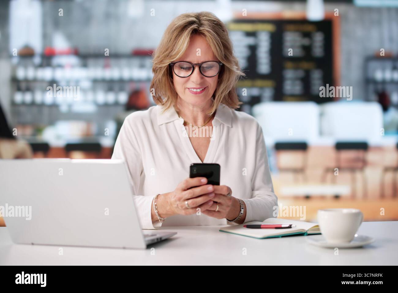 Frau, Die Die Online-Budget-App Nutzt, Um Persönliche Finanzen Im Coffee Shop Zu Verwalten Stockfoto