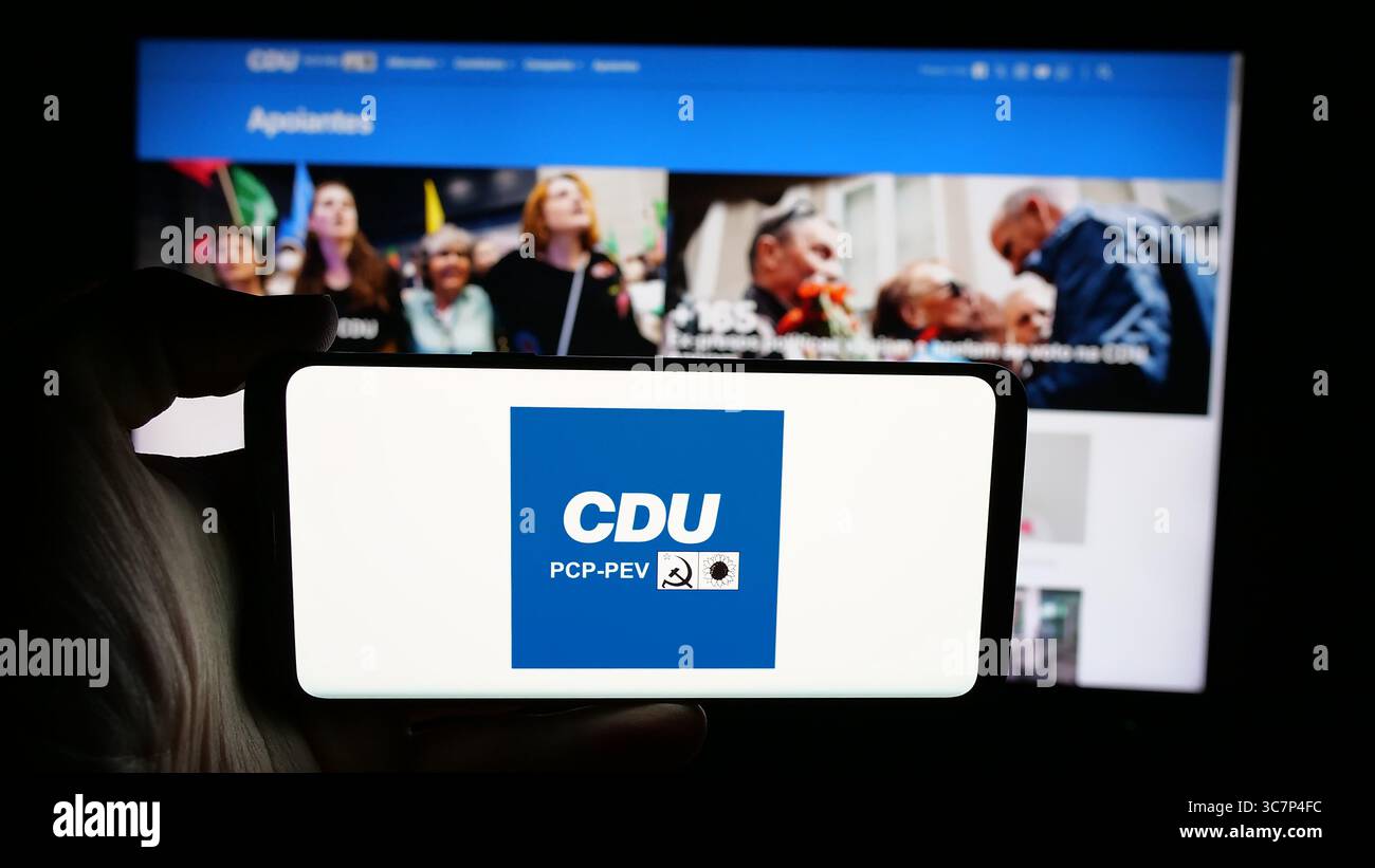 Stuttgart, Deutschland - 18.07.2025: Person mit Handy mit Logo von Coligacao Democratica Unitaria (CDU PCP-PEV) auf dem Bildschirm vor der Webseite. Stockfoto