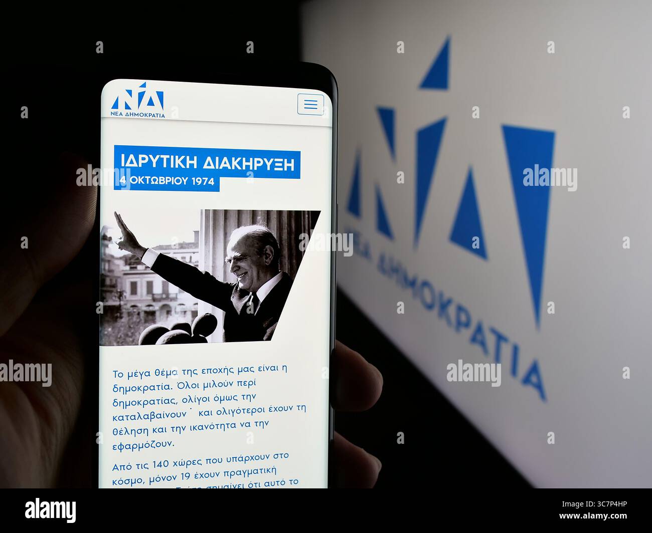 Stuttgart, Deutschland - 18.07.2025: Person, die ein Smartphone hält, mit Webseite der griechischen politischen Partei Nea Dimokratia (ND) auf dem Bildschirm vor dem Logo. Stockfoto