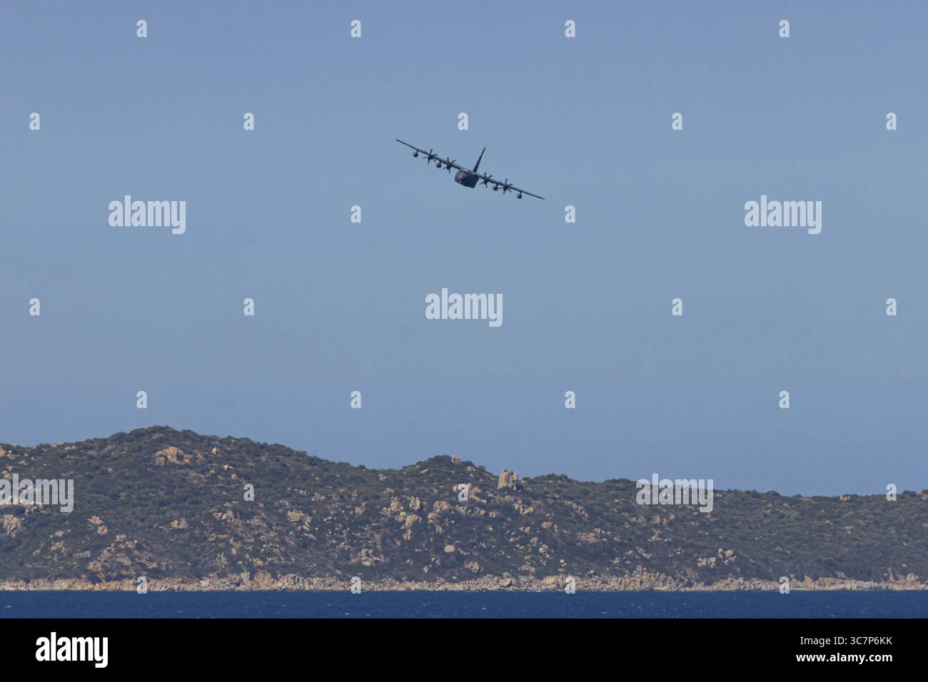 Eine Lockheed Martin MC-130J Commando II, ein Militärflugzeug der US Air Force, fliegt tief über Costa Rei, einem Küstengebiet der italienischen Mittelmeerinsel Stockfoto