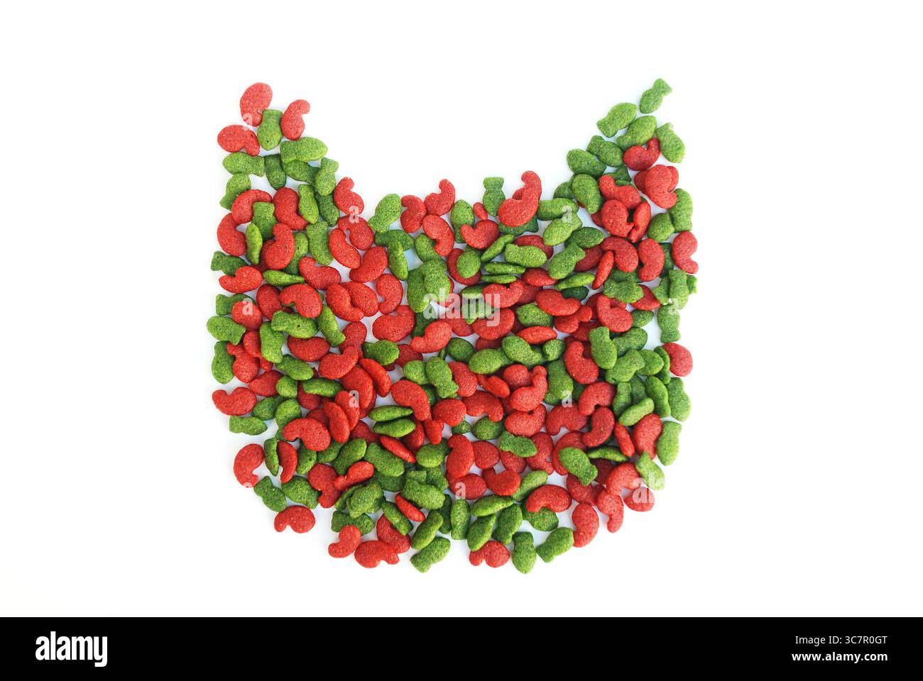 Rote und grüne katzenförmige Kibble, die Katzenkopf-Kontur auf weißem Hintergrund bildet Stockfoto