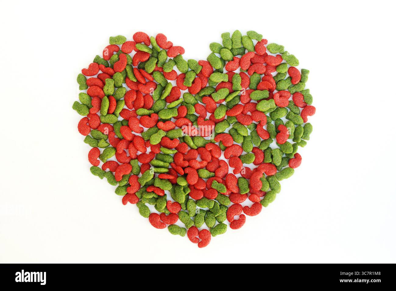 Nahaufnahme von rotem und grünem herzförmigem Trockenfutter, isoliert auf weißem Hintergrund. Stockfoto