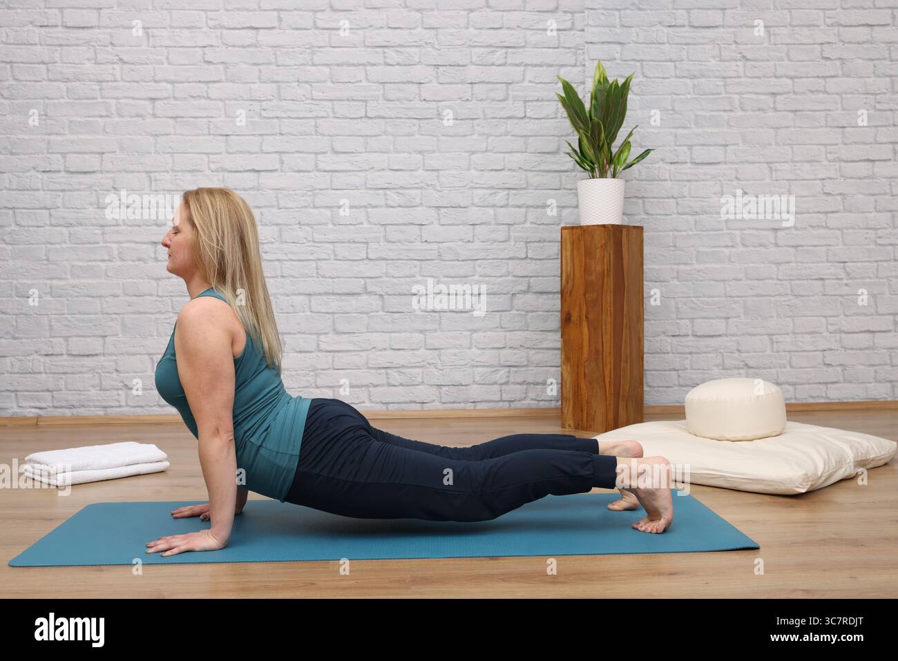 Frau, die Yoga im Yoga-Studio macht - nach oben gerichteter Hund Stockfoto
