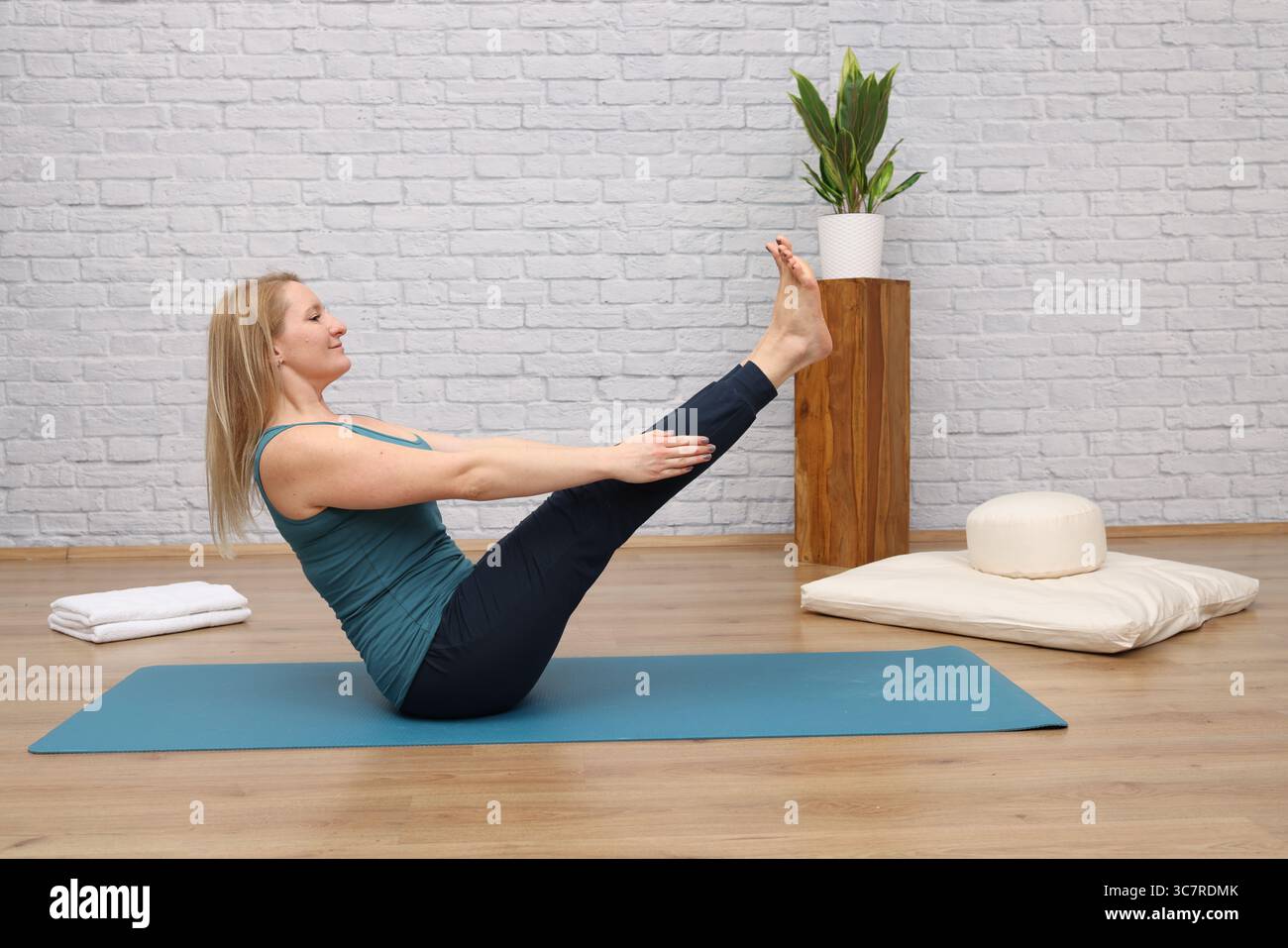 Frau, die Yoga im Yoga-Studio macht - Boot Stockfoto