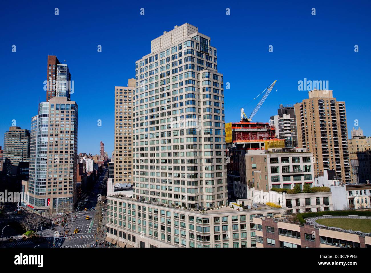 Der Verkehrskreis des Columbus Circle wird von den Geschäften am Columbus Circle und den hoch aufragenden Hochhäusern, einem dynamischen urbanen Drehkreuz unter einem leuchtend blauen Himmel, begrenzt. Stockfoto