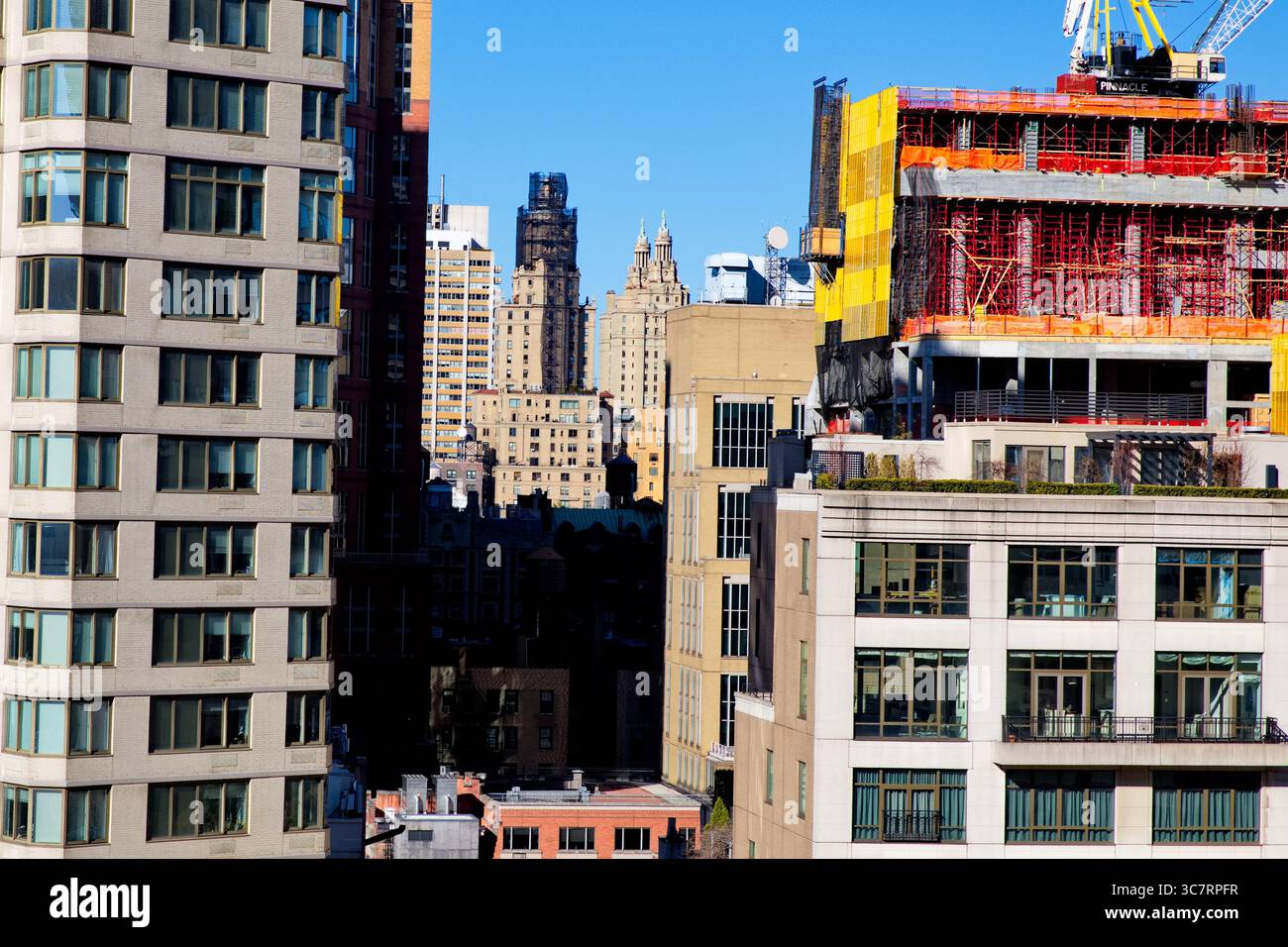 Im Bau befindliches Hochhaus mit Glasummantelung und mittelhoher Flanke mit Blick auf die San Remo Towers im Central Park West unter klarem blauem Himmel. Stockfoto