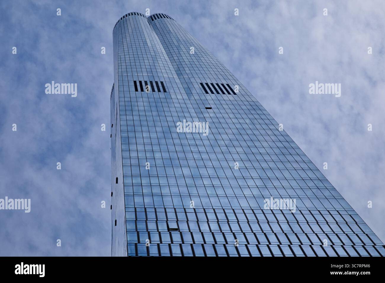 Bestaunen Sie den 35 Hudson Yards Tower, der den Himmel Manhattans durchdringt und die reflektierende Glasfassade Wolken und das pulsierende Stadtleben in beeindruckenden Details einfängt Stockfoto