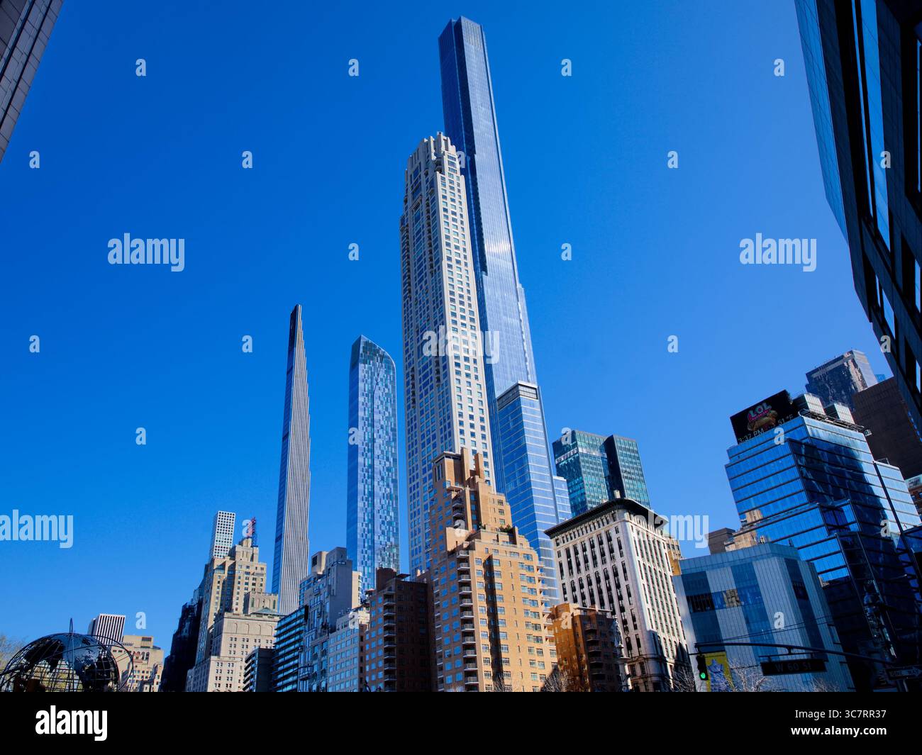 Der Steinway Tower und die 432 Park Avenue ragen hinter historischen Flachhäusern in Manhattans Billionaires’ Row hervor und bilden einen glitzernden Haufen vor einem blauen Himmel. Stockfoto