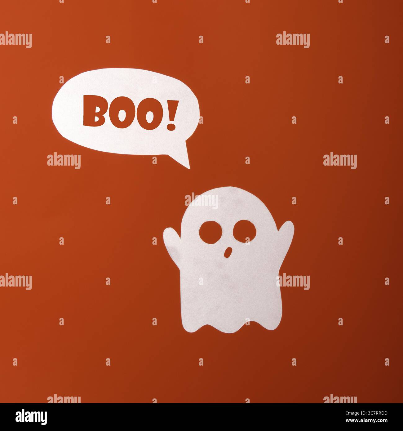 Freundlicher Papiergeist mit einer Blase von Text Buh auf orangem Hintergrund Stockfoto