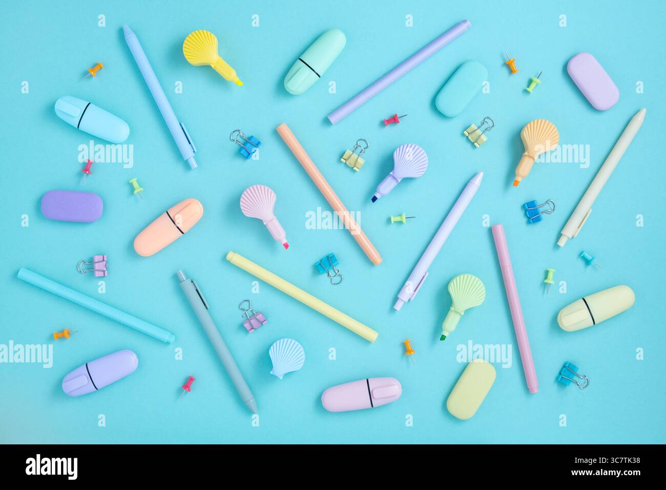 Schulpastellfarben Zubehör. Schreibwaren auf pastellfarbenem mintgrünem Hintergrund. Textmarker in Form von Schalen. Flache Lagen. Stockfoto