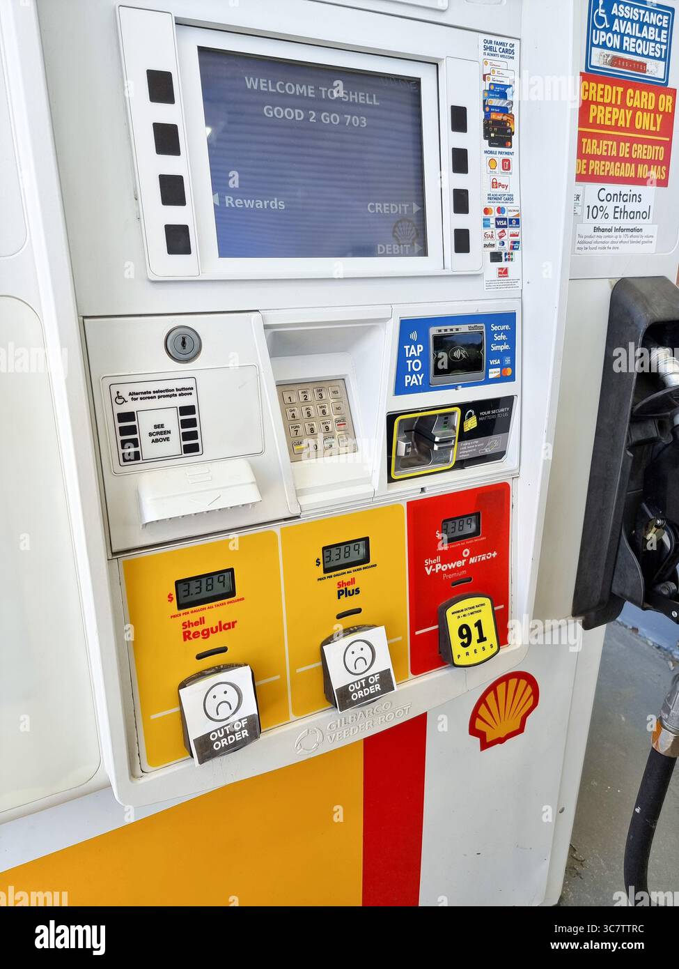Kraftstoff-/Gas-/Benzinpumpe mit Aufklebern „Out of Order“ + Emoji auf Tasten für preiswertere Kraftstoffarten, sodass nur teurer Premium-Kraftstoff verfügbar ist - Smartphone-aufgenommenes Stockfoto