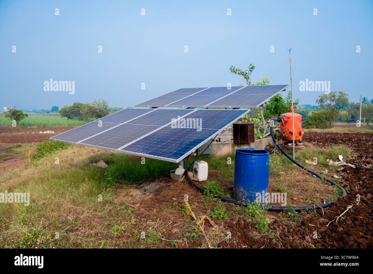 Solarbetriebene Panels werden auf landwirtschaftlichen Flächen, Feldern oder Farmen installiert. Reihen von Solarpaneelen mit nachhaltiger Energie, die auf landwirtschaftlichen Wiesen auf dem ländlichen Feld installiert sind Stockfoto