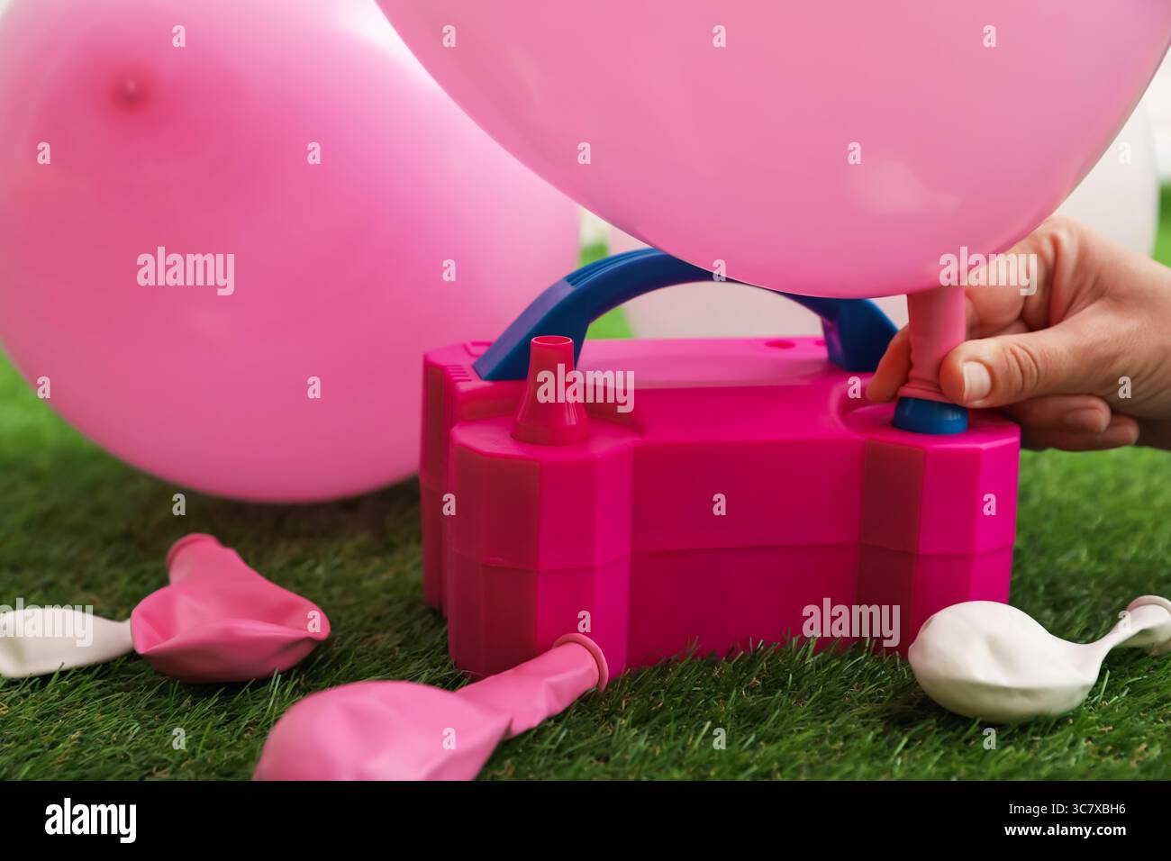 Frau, die einen Ballon mit Luftpumpe im Haus aufbläst, Nahaufnahme Stockfoto
