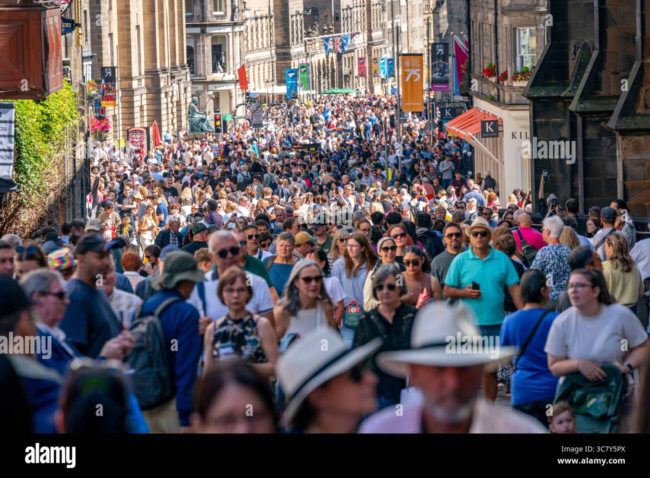Edinburgh, Schottland, Großbritannien. August 2025. Die Edinburgh Royal Mile ist mit Besuchern und Straßenkünstlern an einem heißen, sonnigen Eröffnungswochenende der Fringe und internationalen Festivals beschäftigt. PIC; sehr befahrene Straße, die zum Edinburgh Castle führt. Credit; Iain Masterton/Alamy Live News Stockfoto