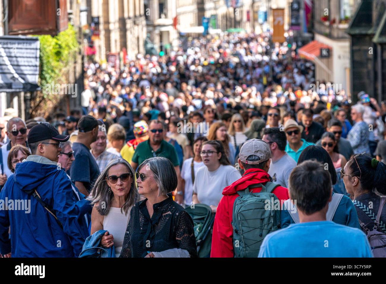 Edinburgh, Schottland, Großbritannien. August 2025. Die Edinburgh Royal Mile ist mit Besuchern und Straßenkünstlern an einem heißen, sonnigen Eröffnungswochenende der Fringe und internationalen Festivals beschäftigt. PIC; sehr befahrene Straße, die zum Edinburgh Castle führt. Credit; Iain Masterton/Alamy Live News Stockfoto