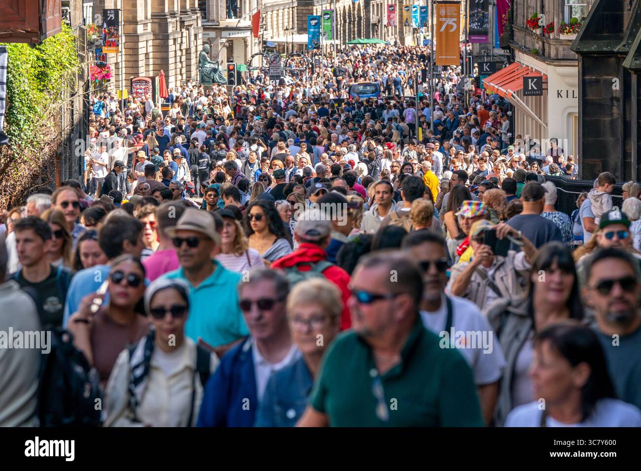 Edinburgh, Schottland, Großbritannien. August 2025. Die Edinburgh Royal Mile ist mit Besuchern und Straßenkünstlern an einem heißen, sonnigen Eröffnungswochenende der Fringe und internationalen Festivals beschäftigt. PIC; sehr befahrene Straße, die zum Edinburgh Castle führt. Credit; Iain Masterton/Alamy Live News Stockfoto