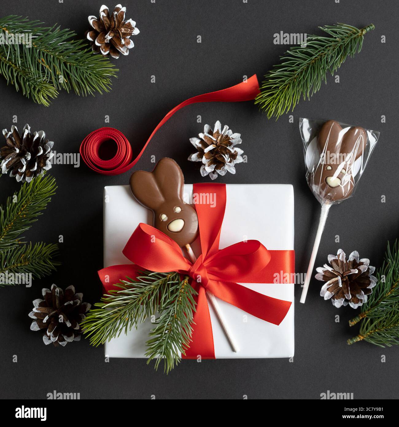 Geschenkbox mit Schokoladenkaninchen dekoriert. Eine Geschenkidee für Kinder zu Weihnachten. Flach. Stockfoto